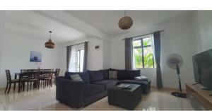 a living room with a blue couch and a table at Oasis Apartment in Pereybere