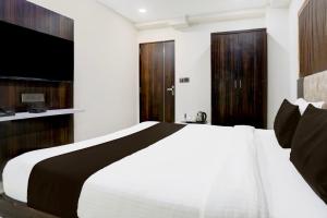 a bedroom with a white bed and a television at Super Hotel O Nana Chiloda Near Airport Formerly Green Valley in Ahmedabad