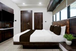 a bedroom with a large bed and a television at Super Hotel O Nana Chiloda Near Airport Formerly Green Valley in Ahmedabad