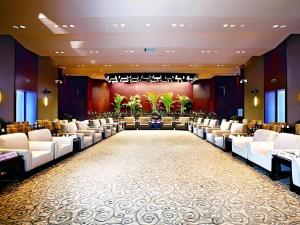 泉州Quanzhou Guest House Hotel的一个带白色椅子和桌子的大型宴会厅 更多246张照片