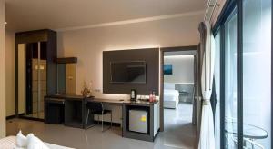 um quarto com uma secretária e uma televisão numa sala em Pasub grand hotel em Udon Thani