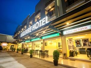 SuizoL Square Hotel的夜晚的建筑物店面