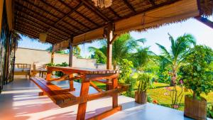 luxury villa in Nosy Be Ambaro في Ambaro: شرفة مع طاولة خشبية وكراسي عليها