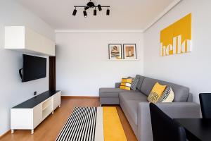 Una sala de estar con un sofá y un televisor en Cozy M3 at Pojezierska Street, en Łódź