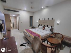 um quarto com uma cama, uma mesa e cadeiras em Townhouse Kakinada Nagamalli Thota Junction em Kākināda