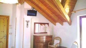 a room with a tv and a table and chairs at Albergo alla Posta B&B in Roana