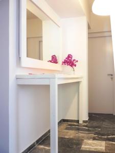 a bathroom with a white vanity with a mirror at Flower Garden in Mati