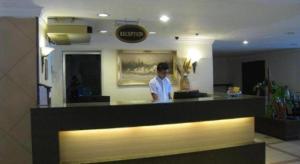 Ein Mann steht an einem Tresen in einem Restaurant. in der Unterkunft Hotel Centrepoint (Self Check In After 5PM) in Kuala Lipis