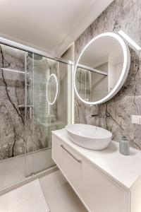 een witte badkamer met een wastafel en een spiegel bij Apartament Opal Centrum Lublin in Lublin