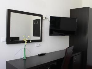 En tv och/eller ett underhållningssystem på Aariana Hotel