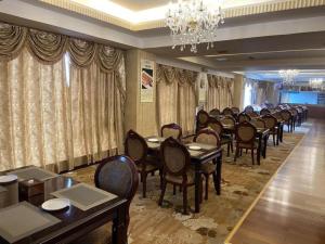 昆明Kunming Plateau Pearl Hotel的一间有桌椅和枝形吊灯的餐厅