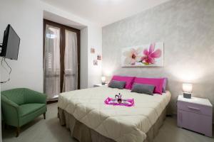 - une chambre avec un grand lit et un plateau rose dans l'établissement Casa Petra ai Quattro Canti, à Palerme