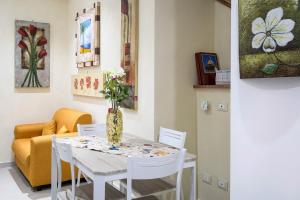 Un comedor con una mesa con un jarrón de flores encima. en Casa Petra ai Quattro Canti, en Palermo