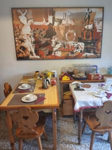 una sala da pranzo con due tavoli e una foto sul muro di Bed And Breakfast Arcobaleno a Bologna