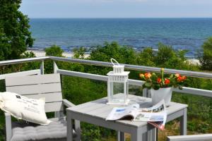 una mesa y sillas en un balcón con vistas al océano en Strandperle, en Juliusruh