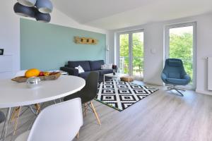 a living room with a white table and chairs at Strandperle in Juliusruh