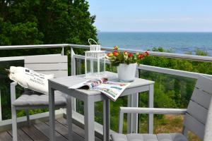 a white table and chairs on a balcony with the ocean at Strandperle in Juliusruh