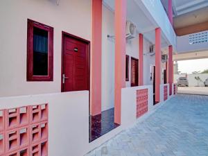 Sultan Syarif Kasim II International AirportOYO 92946 Dekna Homestay Syariah的大楼一侧的红色门