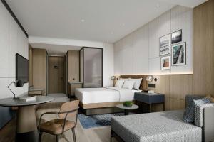 ein Hotelzimmer mit einem Bett und einem Tisch in der Unterkunft Four Points by Sheraton Wuhan Hankou in Wuhan