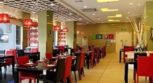 ein Esszimmer mit roten Stühlen und Tischen in einem Restaurant in der Unterkunft Tomolo Hotel Wuzhan Branch in Wuhan