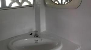 a white sink in a bathroom with a window at Palm Point Village in Mae Nam