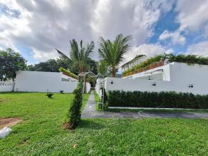 拉威海滩Lotus Bleu Resort & Restaurant的白色的房子,有棕榈树的院子