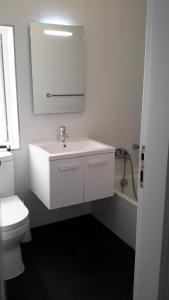a white bathroom with a sink and a toilet at AM Apartments in Sliema
