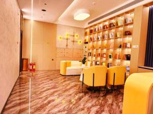a waiting room with yellow chairs and a table at GreenTree Inn Datong YundinGYAyuan Express Hotel in Datong