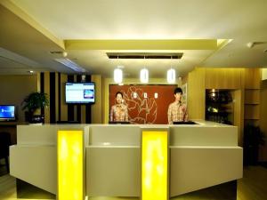 a lobby with two men standing at a counter at 7 Days Premium Xi'an Dayan Tower Xiaozhai Metro Station in Xi'an