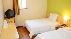 pokój hotelowy z dwoma łóżkami i telewizorem w obiekcie 7 Days Inn Changzhou Yancheng Technology Metro Station w mieście Changzhou +173 zdjęcia