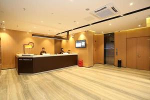 长沙IU Hotel Changsha Yuanjialing Metro Station 2nd Hospital of Xiangya的建筑物内的大堂设有接待台。