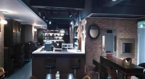 石家庄James Joyce Coffetel Shijiazhuang the Mixc Xinbai Plaza Metro Station的餐厅里的酒吧，有椅子和柜台