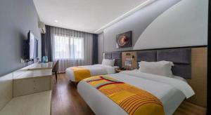 um quarto de hotel com duas camas e uma televisão em Pai Hotel Xi'an Electronic Zheng Street em Xian