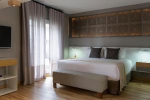 a bedroom with a large white bed and a window at Hotel Arenales in Buenos Aires