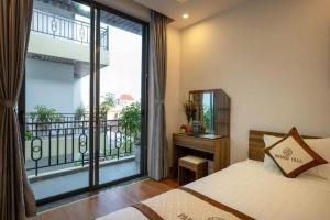 会安Hoi An Paradise Villa的一间卧室，里面有一张床和一扇大窗户。 更多110张照片