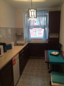 a kitchen with a sink and a window with blue curtains at Apartment KronDays in Braşov