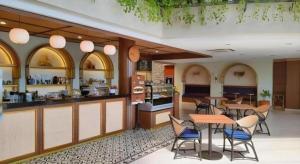 una cucina e una sala da pranzo con tavoli e sedie di Bentani Hotel & Residence a Tangkil