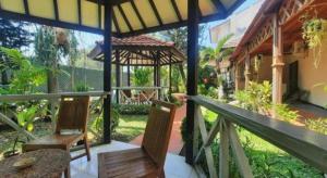 un portico di una casa con due sedie e un tavolo di Bentani Hotel & Residence a Tangkil