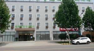 a white car parked in front of a building at GreenTree Inn Langfang Xianghe County Robot Venture Port in Xianghe