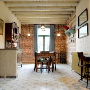 a dining room with a table and a brick wall at 't Schippershuis in Vurste