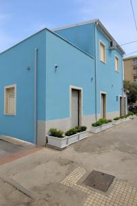 een blauw gebouw met planten op een parkeerplaats bij La Dolce Sosta in Crotone +7 foto's