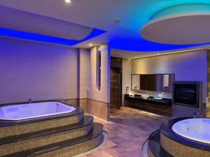 ein großes Badezimmer mit zwei Badewannen und einem Fernseher in der Unterkunft Wei Feng Exquisite Motel Pintung Branch in Pingtung