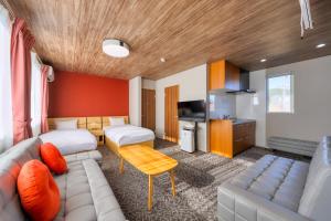 a hotel room with a couch and a bed at 西裏ステイ なか富士 Nishiura stay Naka Fuji in Fujiyoshida