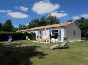 莫雷勒斯Gîte Lavande - Gîtes Au Bas Marais的院子里的白色棚子,配有桌椅