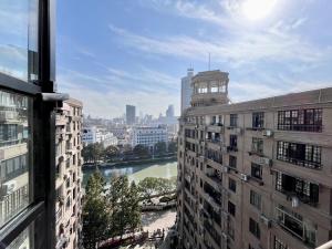 Shanghai Zighouse--The Bund Premium Apartment Suites في شانغهاي: اطلالة على نهر بين مبنيين