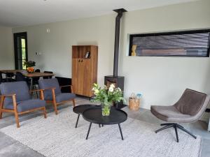 a living room with chairs and a table with a vase of flowers at Luxurious detached water villa with jetty in Balk +266 photos