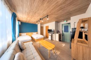 a hotel room with a couch and a table at 西裏ステイ なか富士 Nishiura stay Naka Fuji in Fujiyoshida