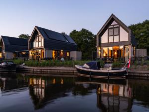 a boat is docked in front of a house at Luxurious detached water villa with jetty in Balk