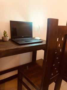 a laptop computer sitting on top of a wooden desk at Coco Breeze Villa in Talpe