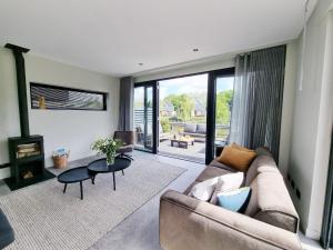 a living room with a couch and a table at Luxurious detached water villa with jetty in Balk